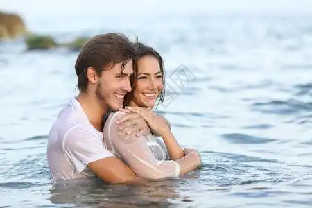 男孩女孩接吻相爱的年轻情侣在水中约会背景