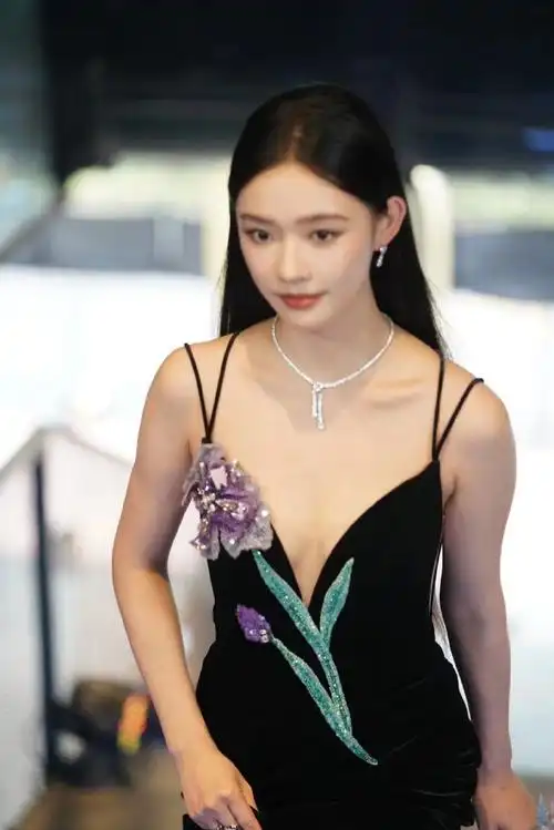 黑色吊带长裙质感十足,胸前的紫色花卉与美甲相呼应,再加上透亮钻石