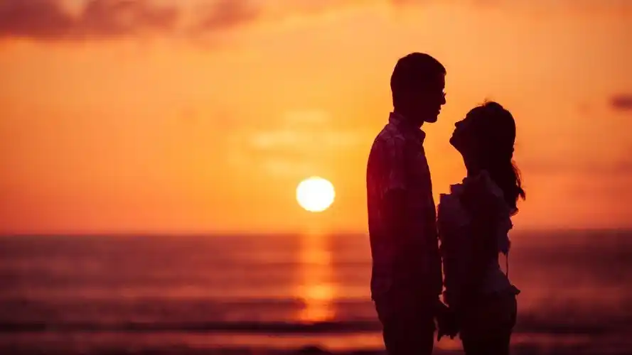 浪漫年轻情侣日落海洋海滩图片