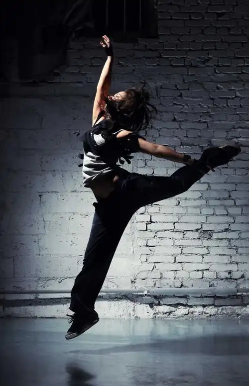 女孩穿着休闲服跳舞图片-灰色背景前穿着休闲服装跳舞的女孩素材-高清