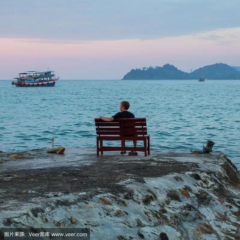 一个人独自坐在海边的石崖上