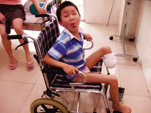 另一张轮椅是成年人用的,但只有10岁的截肢儿童周乐训坐上去,那张轮椅