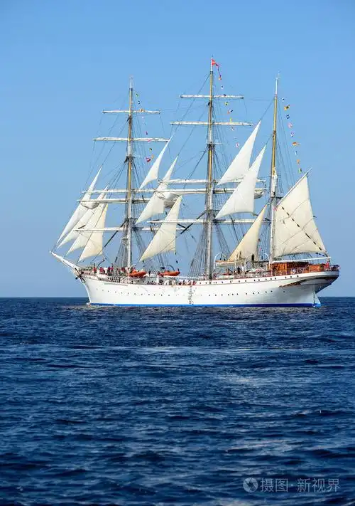 旧历史高船与白色风帆在蓝色的大海