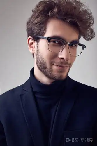 时尚肖像,英俊优雅的男人,卷发,穿西装,戴灰色背景眼镜,在工作室