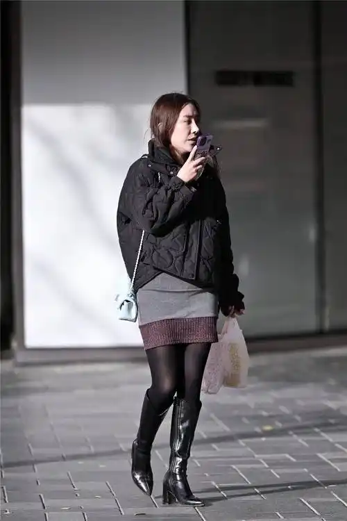 也呈现出个性的效果,靴筒到膝盖下面一些的位置,搭配黑色丝袜,在阳光