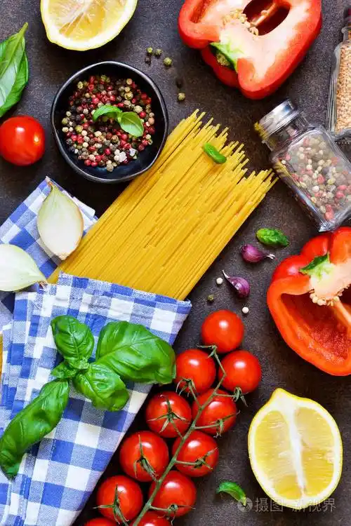 意大利食物背景烹饪意大利面的原料意大利面条番茄罗勒和胡椒在黑暗的