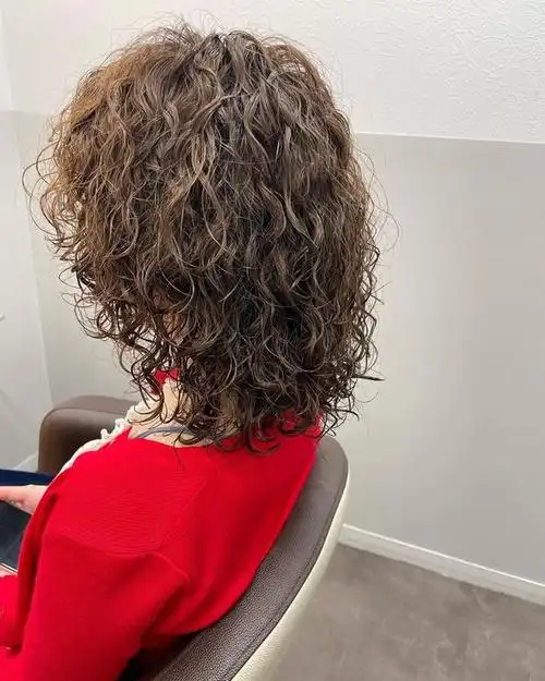 为了打造这个发型,您可以使用一个较大的卷发棒或者卷发器,将发丝卷曲