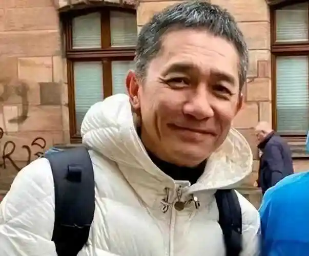 61岁梁朝伟德国与路人合影满头白发笑容灿烂