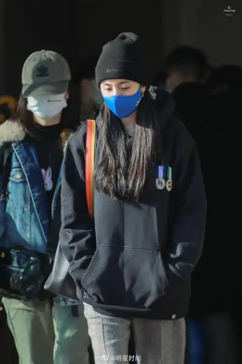 杨幂最新机场照,黑色针织冷帽配以黑色连帽卫衣 宽松长裤