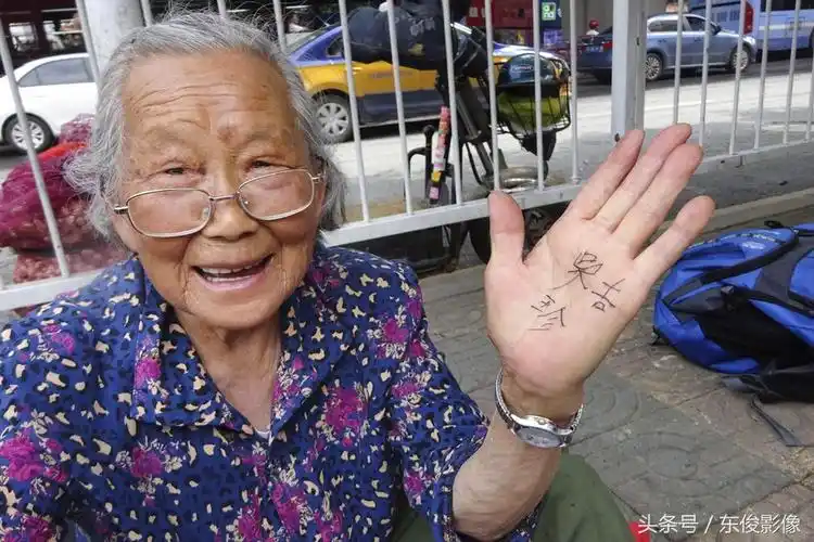 老人在手心上写她的名字给旁人看.有行人停步问价?