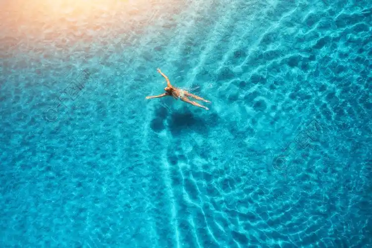 在夏天挥动透明水顶视图在海边度假假期在日落时分在地中海游泳女人