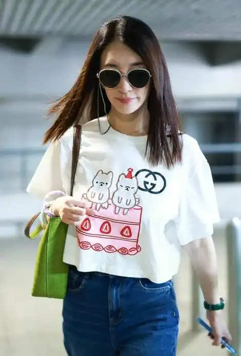 李小冉上身穿白色的卡通t恤,下身搭配蓝色破洞牛仔裤,凸显出很好的