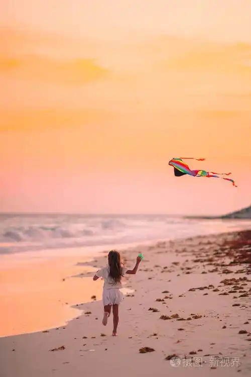 小女孩在海水湍急的海滩上放风筝