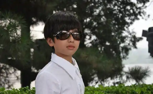 蔡徐坤小时候深夜在街边玩耍,手上好像是拿着类似于风筝的东西,这么晚