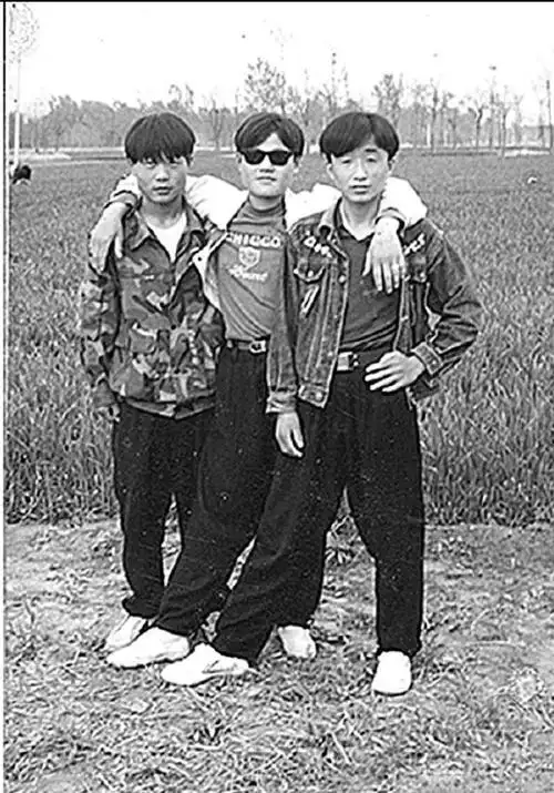 1990年中国历史老照片:图为4名小学生在学校的操场上打羽毛球,那时大