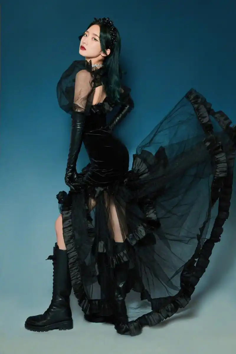 孟美岐身着黑色网纱连衣裙,搭配皮手套和长靴,戴着精致的黑色头饰