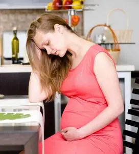 孕妇腹痛美丽的孕妇心情不好在床上悲伤的孕妇胃痛摸她的肚子,痛在