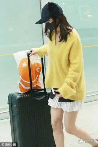 杨幂身穿嫩黄毛衣配短裙