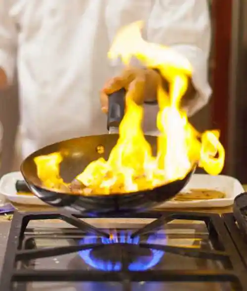 厨师用平底锅烹饪火焰
