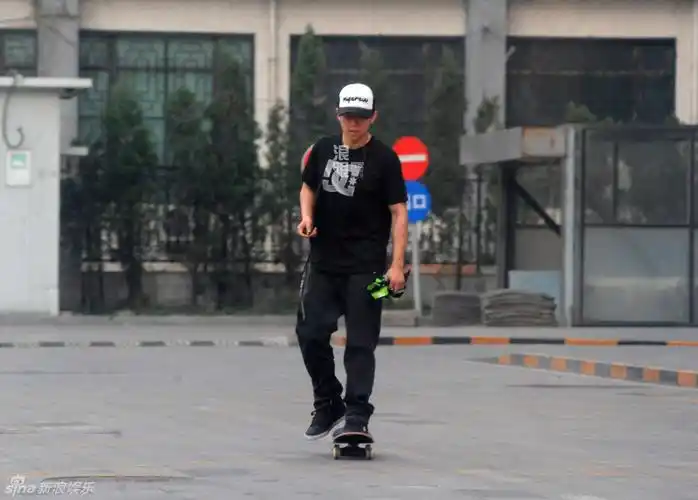 日前某天下午,夏雨身穿一身黑衣黑裤,戴着棒球帽在某小区空地玩滑板