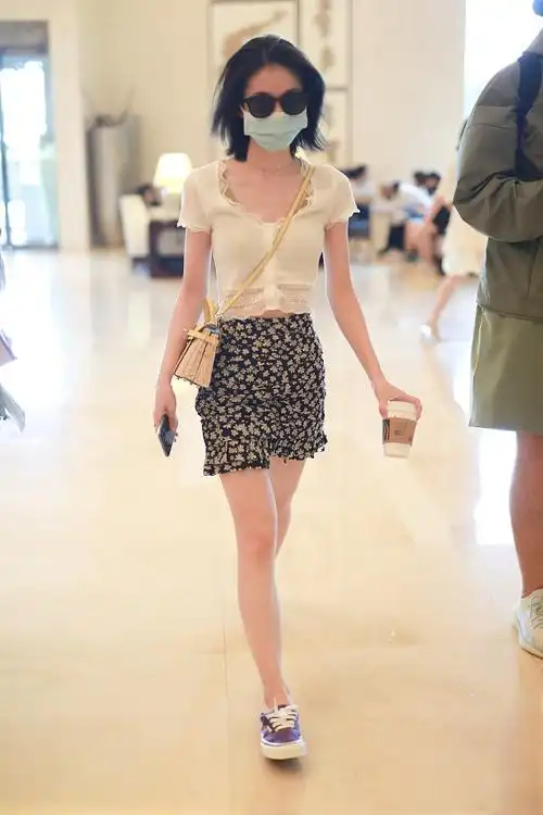 张雪迎穿白色上衣搭短裙现身机场 一路捣鼓竹篮包超吸睛