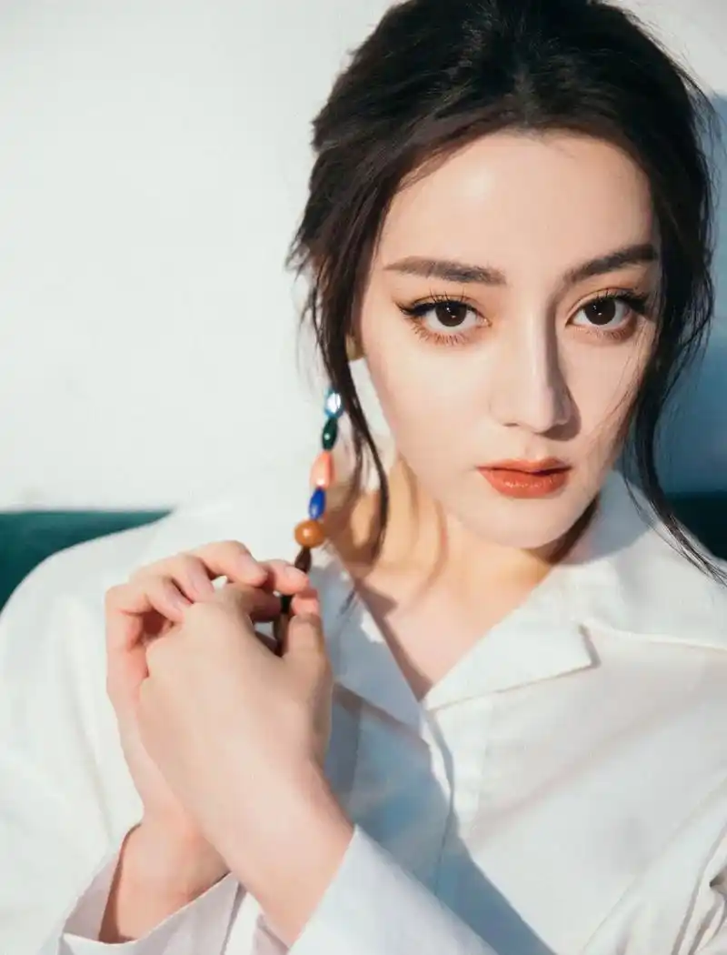 迪丽热巴的身材是真的好,穿白色修身服装戴单只彩色耳坠,整个人时尚