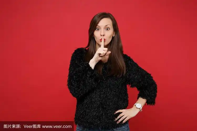 美丽的年轻女子在黑色毛皮毛衣说嘘嘘安静用手指在嘴唇嘘嘘手势孤立在