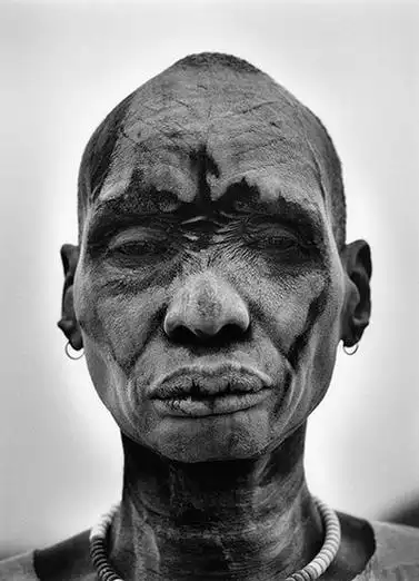 2006年,苏丹南部的一名丁卡族人把烧过的牛粪灰烬涂抹在脸上和身上,以