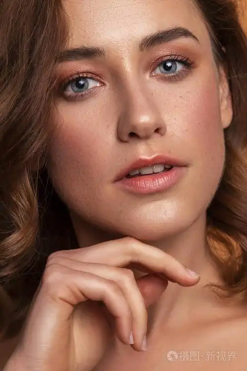 新鲜干净的皮肤,晚上化妆和雀斑. 手靠近她的脸. 特写肖像.