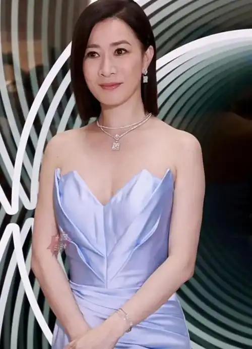 48岁佘诗曼最新活动造型,一袭深紫色抹胸长裙明媚动人!