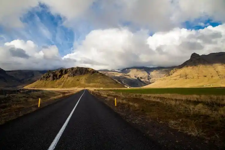 在遥远的山间棕色草地之间的混凝土公路n1高清壁纸