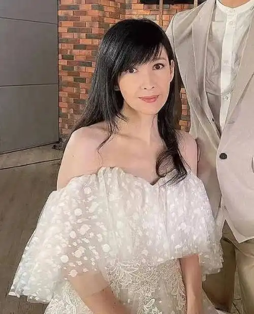 53岁周慧敏近况曝光穿露肩长裙端坐钢琴前皮肤白无皱纹不显老