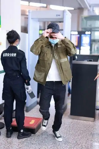 欧豪身穿军绿色外套仿佛特种兵,独自拎大包小裹赶行程