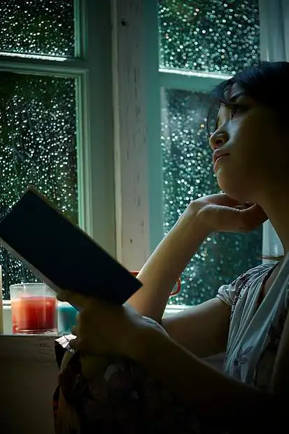 下雨天在窗边读书的孤独女性