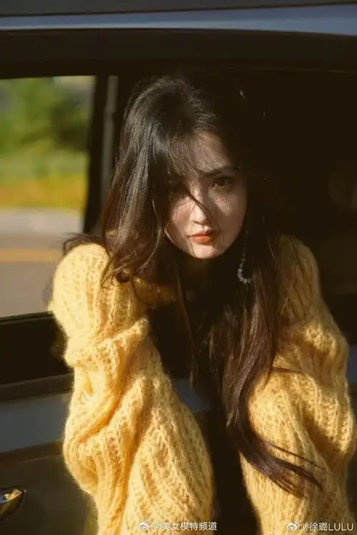 徐璐穿黄色毛衣置身车内拍片长发随风舞动眼神迷人