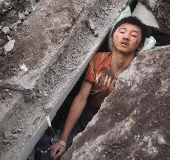 5月13日,在四川省北川县北川中学,一名被压在瓦砾堆中的学生在接受