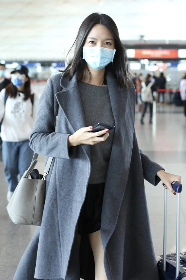 张梓琳私下穿的真低调,一身暗色服装走机场,但也没挡住大长腿
