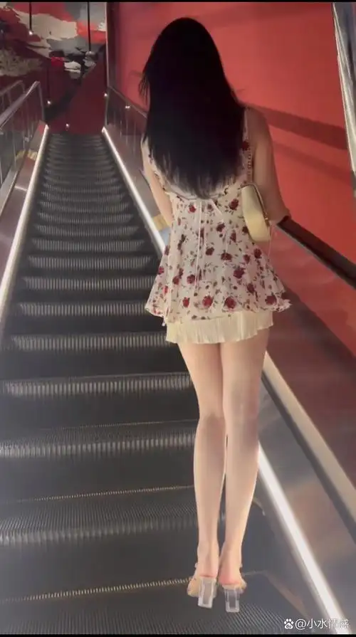 一位女孩站在自动扶梯上,留给我们一个充满魅力的背影