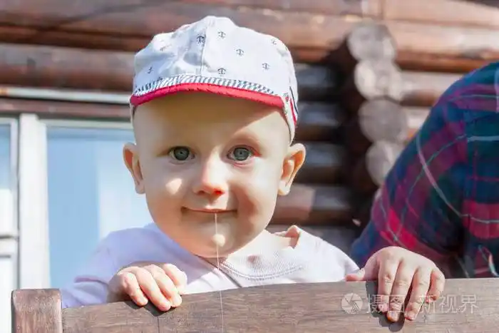 一个微笑的蓝眼睛婴儿流口水的画像