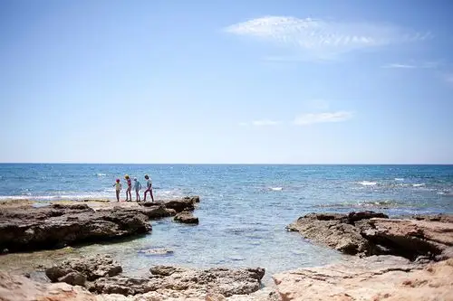 游客在arutas海滩海岸边玩耍.