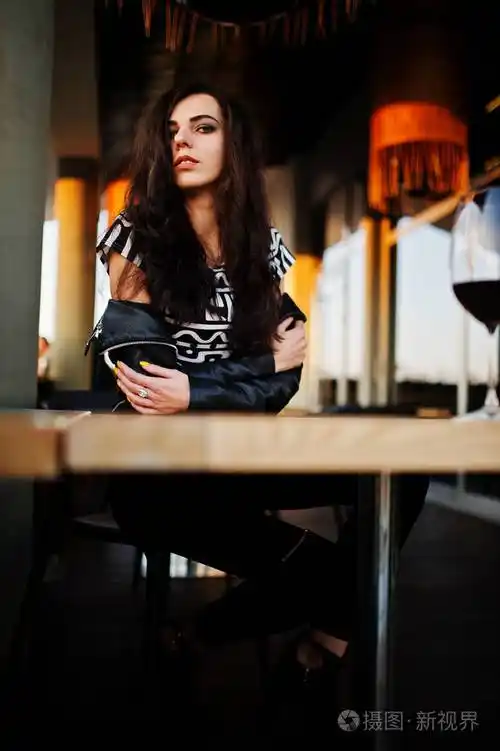 年轻的卷发女人在酒吧里喝酒