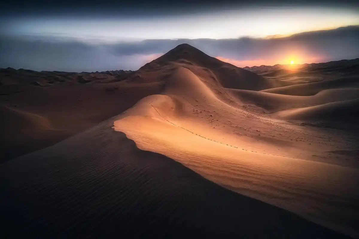 黄昏之韵:青海湖畔沙漠中的落日奇景 无垠的沙漠中,夕阳徐徐落下,余晖