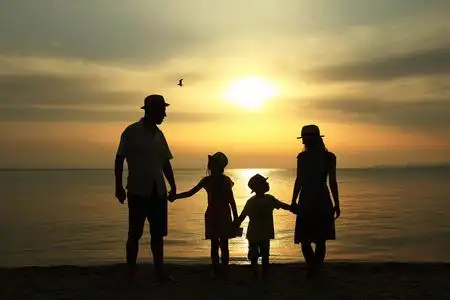 海边夕阳下的家庭剪影照片