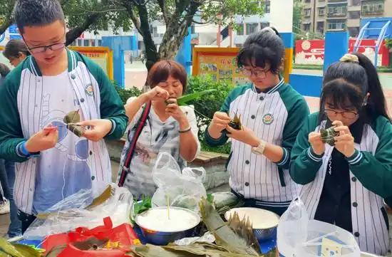 武胜县城南小学六年级学生开展包粽子比赛