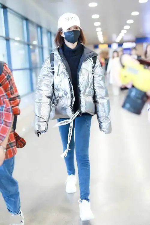 杨紫穿银色羽绒服搭配蓝牛仔裤现身机场,戴棒球帽和口罩遮捂严实