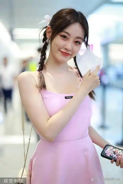 祝绪丹现身机场,穿粉色露背吊带裙露美背,双马尾麻花辫俏皮可爱