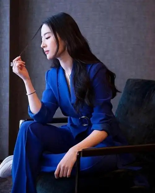 西装采用垫肩和收腰设计,结合流畅利落的裁剪,进一步凸显出刘亦菲率性