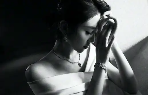 近日,唐艺昕晒出黑白大片,她穿着一字肩礼服,低头沉思的模样很是