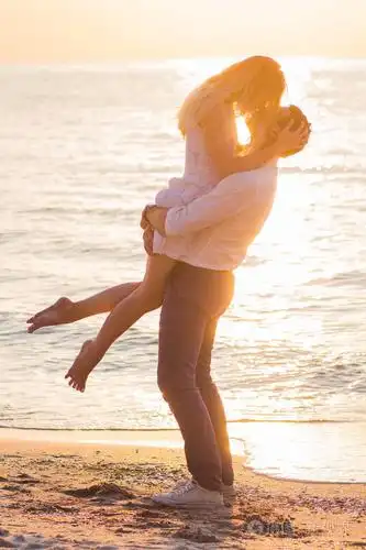 美丽年轻的浪漫情侣接吻在海边在 ri 的光线