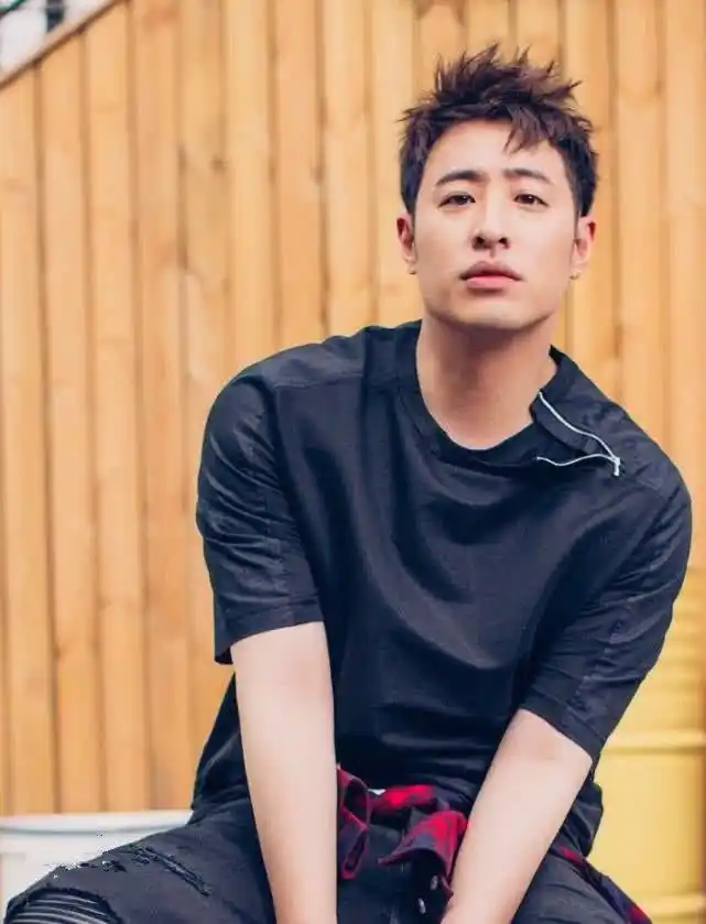 照片中的潘玮柏凌乱的短发中分,戴着一副金丝边框的眼镜,一副青涩又呆